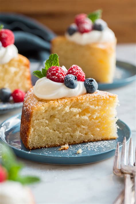 Thematic photo of a slice of moist yogurt cake with mixed berries on a plate, with a fork.
