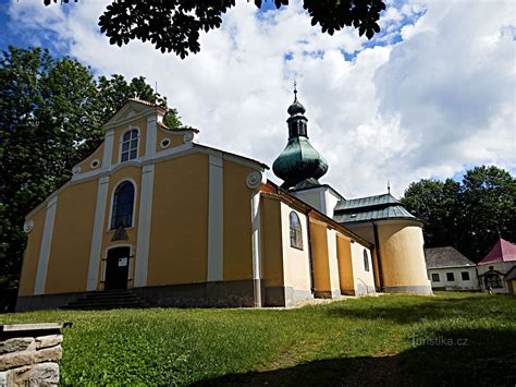 Panoramski posnetek Hrastovelj z vidno cerkvijo Svete Trojice in gostilno