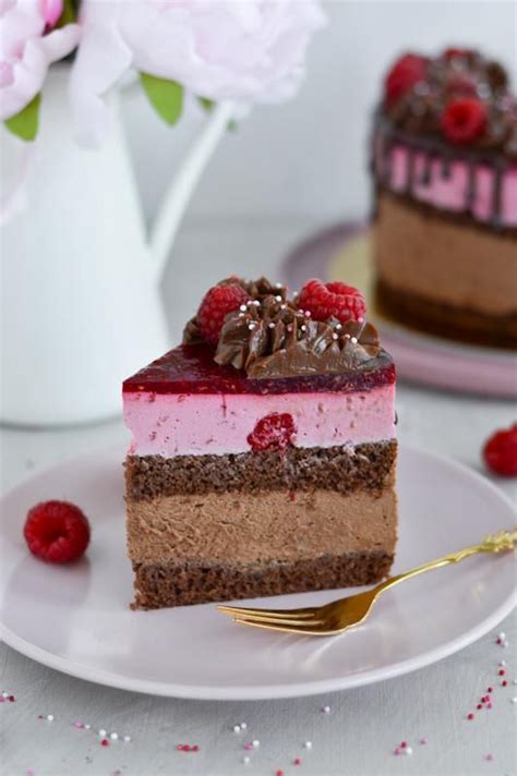 Tematska fotografija nepečene malinove torte, okrašene s svežimi malinami in meto