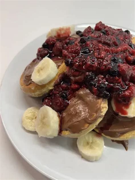 Fotografija zlato-rjave palačinke z banano in pehtranom, okrašene s sadjem