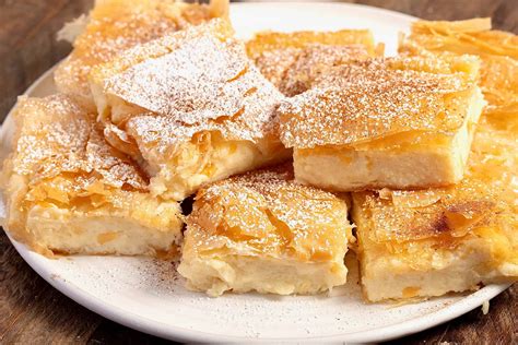 Thematic photo of Bougatsa, a Greek dessert with phyllo pastry and semolina cream, dusted with powdered sugar and cinnamon.