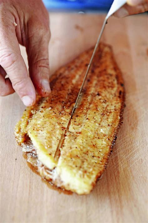 Prikaz čiščenja lososovega fileja in odstranjevanje kosti s pinceto