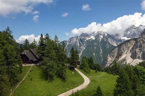 Pogled na gorsko kočo Erjavčeva s slikovito pokrajino Julijskih Alp v ozadju