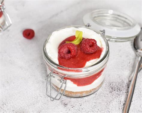 Cheesecake v kozarcu s plastmi piškotov, kreme in sadja.