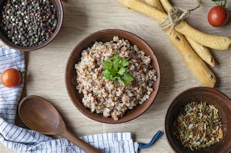 Thematic photo of a bowl of cooked buckwheat porridge, possibly with some fresh herbs or vegetables.