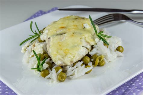 Serviran krožnik s puranjimi zrezki, ananasom, sirom in prilogo