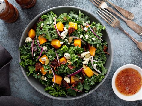 Različne vrste mlade solate v pripravi za obiranje, ki prikazujejo raznolikost listov (rdeči, zeleni, kodrasti, gladki).