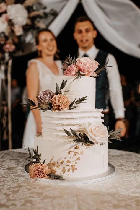 Tematska fotografija poročne torte ob rezanju, osvetljene svečami