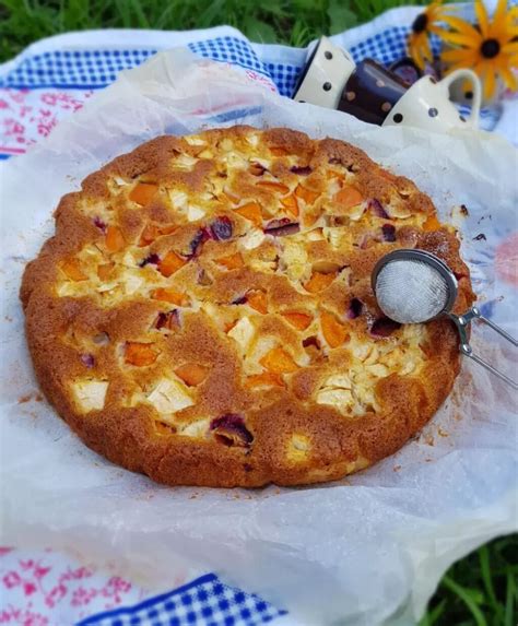 Biskvitni kolač, namazan s stepeno smetano in posut s sadjem