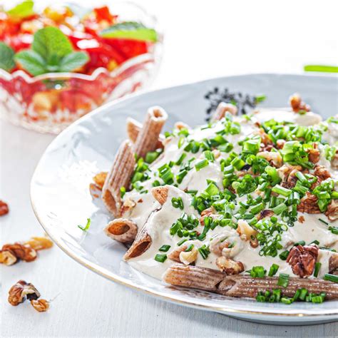 Prikaz hrustljavih piščančjih taquitosov na krožniku, postreženih s svežo pomako in okrasjem.