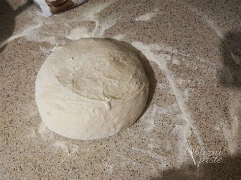 Vzhajano testo za kruh v skledi, pokrito s krpo