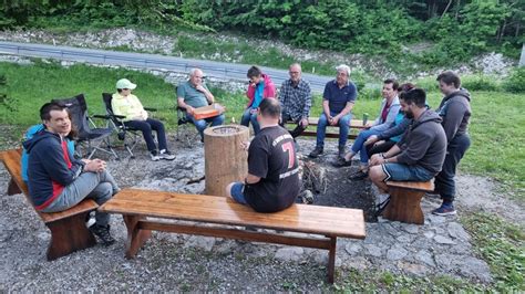 Ilustracija družine, ki kuha golaž na prostem ob ognju s kotličkom.