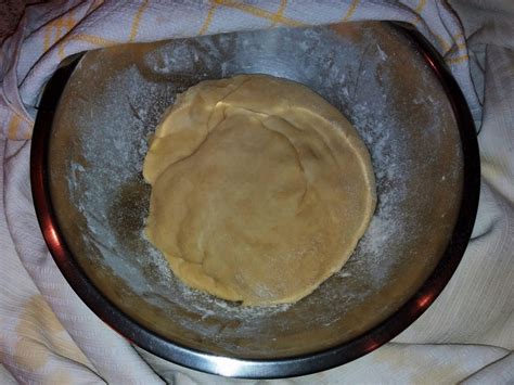 Sveže pripravljeno vlečeno testo za štrudelj, pokrito z oljem in počivajoče v posodi.