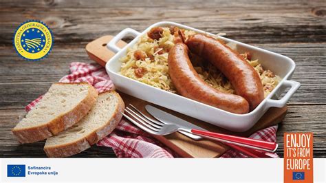 kranjska klobasa položena na krožnik s kislim zeljem