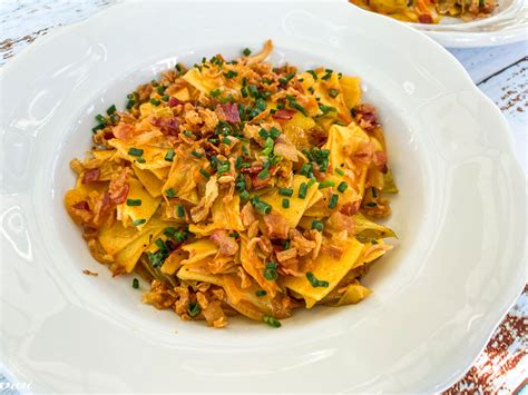 Zeljne krpice na krožniku, posute s peteršiljem in slanino