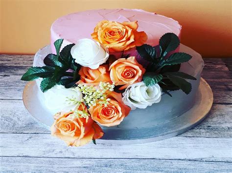 Fotografija torte, bogato okrašene s svežim sadjem in dekorativnimi cvetlicami