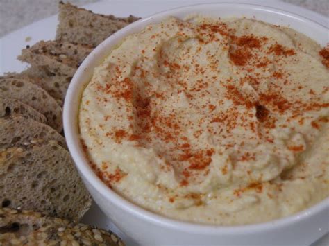Serviran humus v skodelici z olivnim oljem, peteršiljem in pita kruhom