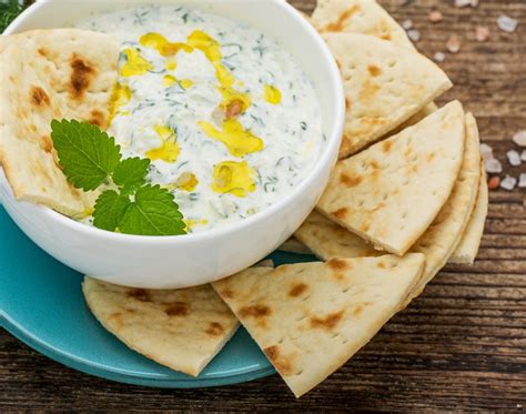 Tzatziki v skledi, grški jogurt in kumare v ozadju