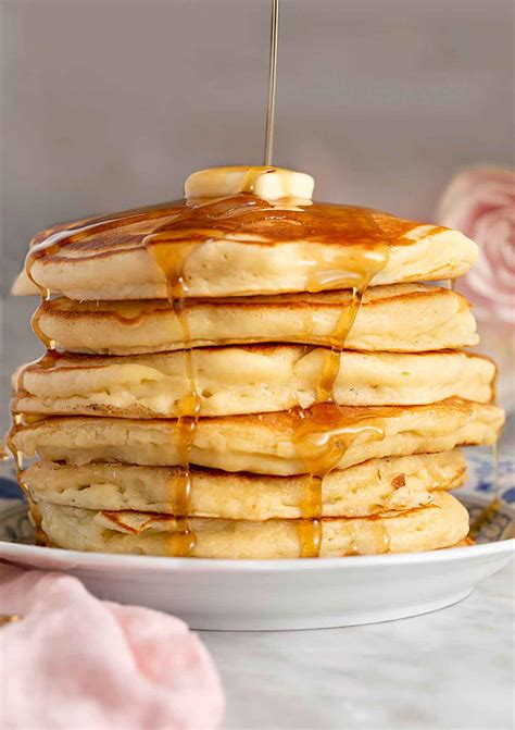 Thematic photo of fluffy American pancakes stacked with syrup