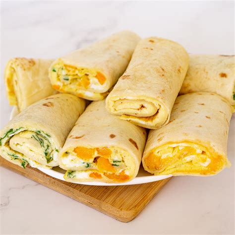 Slika postreženih piščančjih tortilj z različnimi prelivi in prilogami