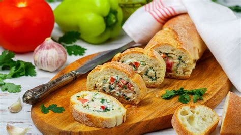 Raznolike sestavine za nadevane francoske štručke, vključno s tuno, sirom, papriko, majonezo in kumaricami