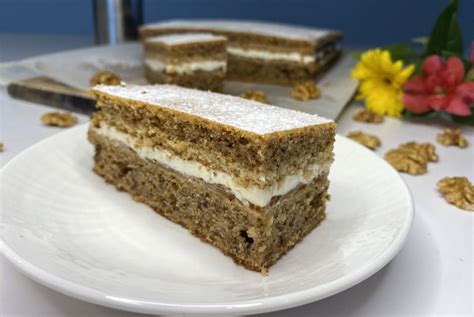 Fotografija servirane sočne orehove torte s poudarkom na dekoraciji in rezu