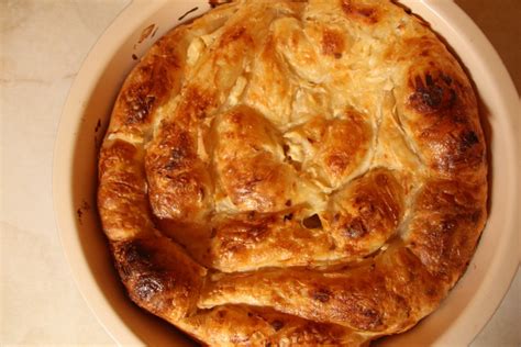 Prikaz sestavin za jabolčni burek in postopek plastenja vlečenega testa v okroglem pekaču.