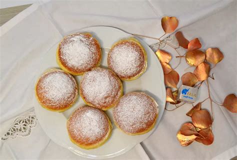 Fotografija kosa zdrobovega peciva, prelitega s sirupom, okrašenega s pomarančno lupinico