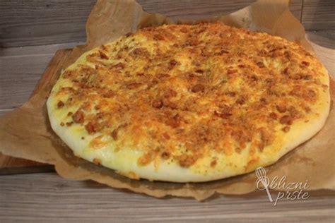 postrežena ocvirkova pogača, raztrgana na kose, ob skodelici enolončnice