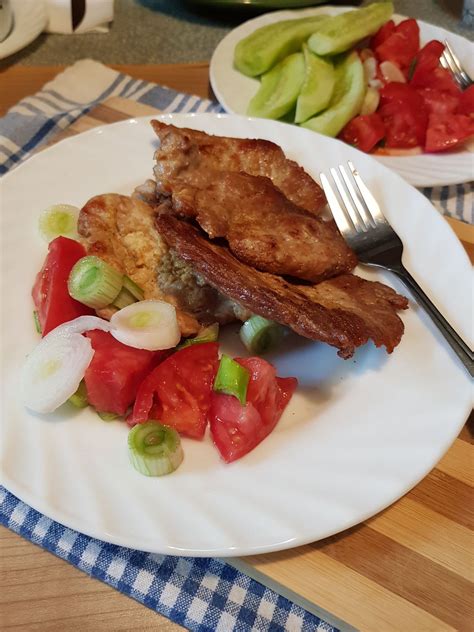 Tematska fotografija pečene svinjske krače na servirnem krožniku z dekoracijo