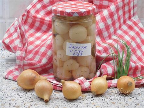Vložena šalotka v kozarcu na leseni mizi