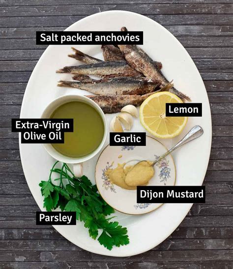 The process of making a mustard sauce with garlic and anchovies in a pan.
