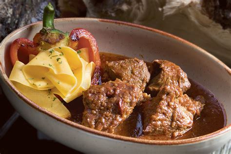 Pripravljen telečji paprikaš v ponvi z gosto omako in koščki mesa