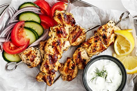 Fotografija piščančjih nabodal (souvlaki) s tzatzikijem in limono