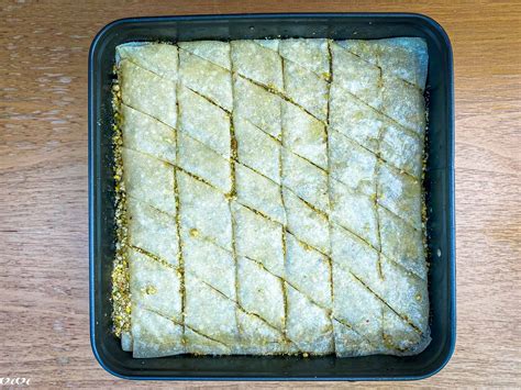 Prikaz zložene baklave pred peko, z vidnimi plastmi testa in orehov