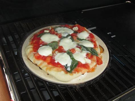 pizza se peče v krušni peči ob ognju