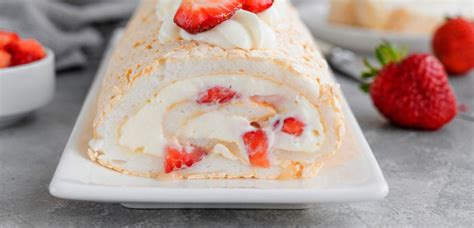 fotografija sladice s plastmi biskvita iz beljakov, smetano in jagodami