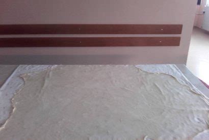 Prikaz razvaljanega vlečenega testa za štruklje, pripravljenega za nanos nadeva.