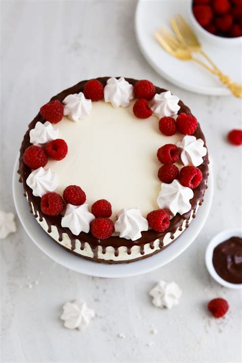 Fotografija torte z malinami, belo čokolado in masleno kremo z dripom