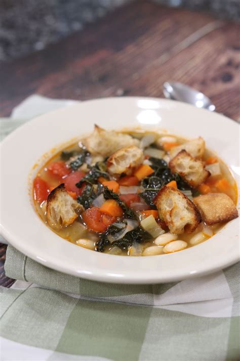 Ribollita v rustikalni keramični posodi, postrežena s koščki kruha