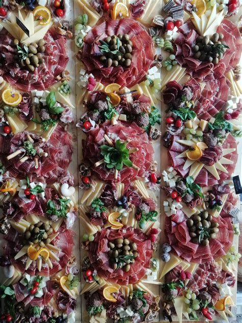 Fotografija servirnega krožnika s tanko narezanim pršutom Parma, melono in parmezanom