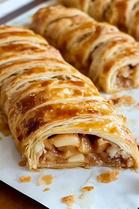Photo showing raw apple strudel rolls wrapped in cling film or baking paper, ready for freezing