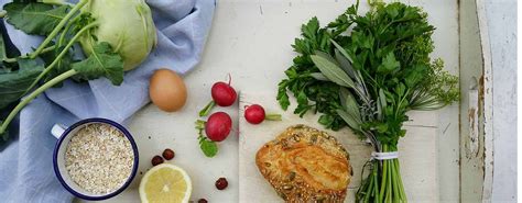 Klasična fotografija Tabbouleha v skledi, okrašena z limoninimi rezinami in svežimi zelišči.