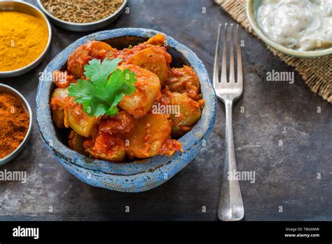 Thematic photo of Indian chicken with potatoes, garnished with fresh coriander