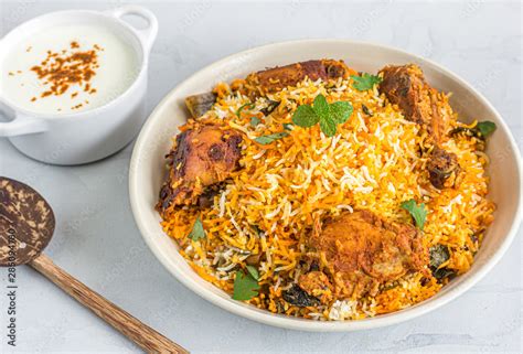 Thematic photo of Chicken Biryani served with raita
