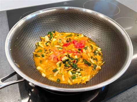 lonci z različno zelenjavo in kostmi, ki se kuhajo na štedilniku