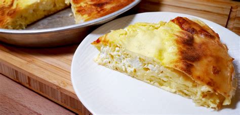 Gibanica v pekaču, pripravljena za peko, z narezanimi odprtinami