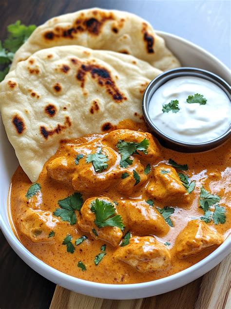Pripravljen Butter Chicken s svežim koriandrom, obdan s basmati rižem in naan kruhom