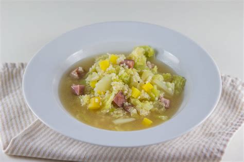 fotografija sklede ohrovtove juhe s kašo, okrašene s peteršiljem