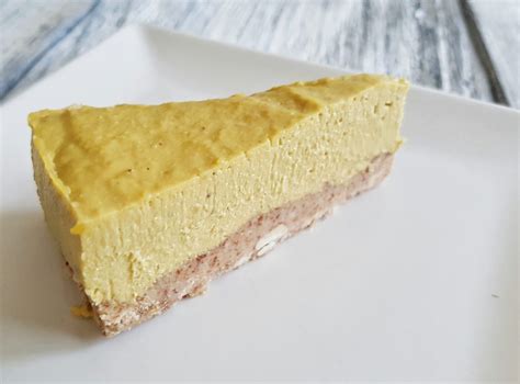 Sestavljena presna mangova torta s svežimi koščki manga in kokosovim posipom.